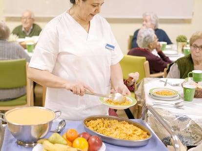 Una mujer sirve comida en una residencia de ancianos.