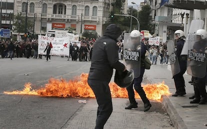 Un manifestante se enfrenta a los antidisturbios en Atenas.