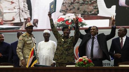 El líder opositor Ahmad Rabie (segundo por la derecha), celebra el acuerdo junto al general Abdel Fattah al-Burhan (centro), durante la ceremonia celebrada hoy en Jartum.