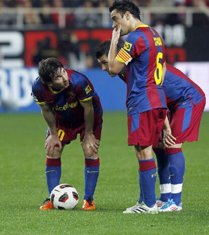 Messi, Villa y Xavi estudian el lanzamiento de una falta contra el Sevilla.