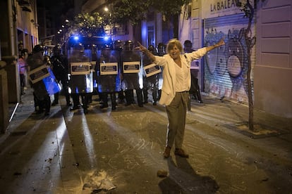 Una senyora es posa entre els manifestants i la policia a Gràcia.