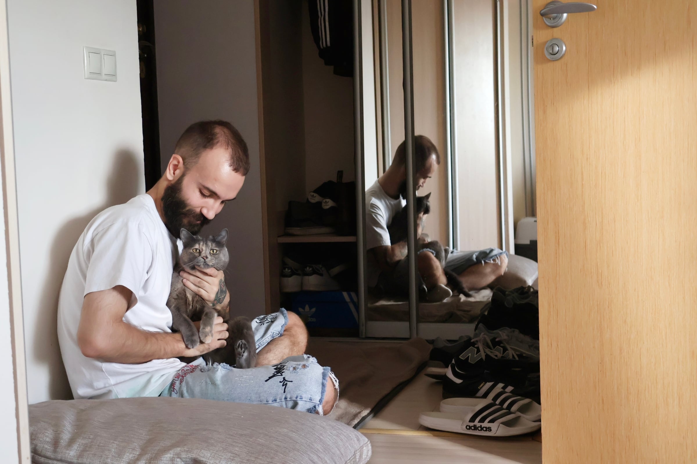 Dima y su gata, en el rincón de su apartamento en Kiev donde se cobijan durante los bombardeos rusos.