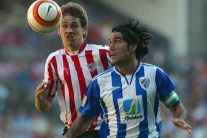 Fernando Sanz disputa el balón ante Llorente.