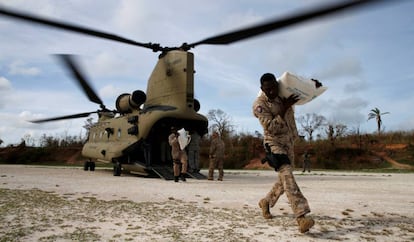 A soldier carrying humanitarian aid in the aftermath of Hurricane Matthew.