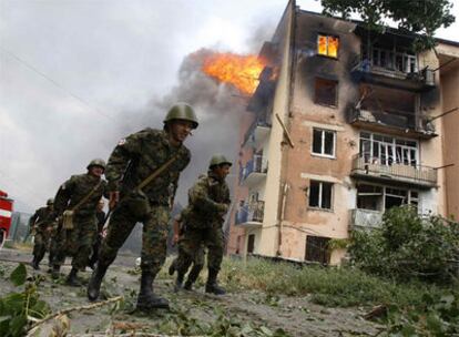 Soldados georgianos pasan junto a un edificio en Gori alcanzado por la aviación rusa, en agosto de 2008.