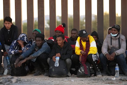 Un grupo de migrantes esperan a ser procesados por las autoridades migratorias estadounidenses, en Lukeville. 