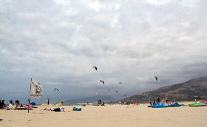 Gente practicando Kitesurf en una playa de Tarifa.