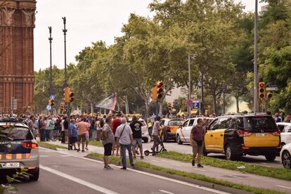 Un grupo de taxistas lanza bombas de humo junto a la polic&iacute;a en Barcelona durante su protesta contra Uber y Cabify de julio de 2018.