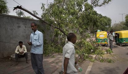 Un grupo de hombres entre los desperfectos causados por una tormenta en Nueva Delhi este domingo.