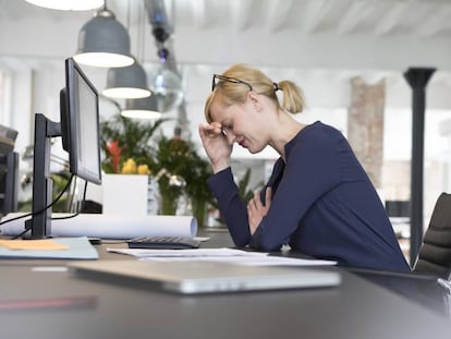 Una mujer estresada en el trabajo. 