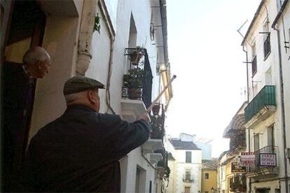 Un vecino de Plasencia indica a otro la vivienda donde fueron localizados ayer los cadáveres.