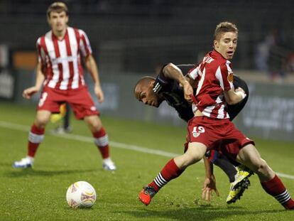 Muniain lucha por controlar el balón con Briand