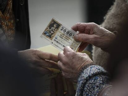 Un mujer guarda un décimo de lotería en un sobre en Sevilla.