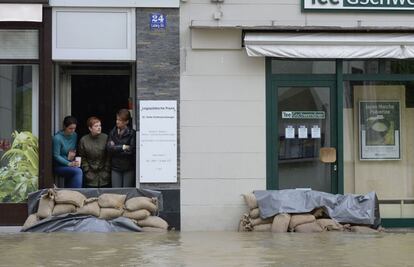 Tres mujeres observan una calle inundada en la localidad bávara de Passau, protegidas por sacos terreros. Esta ciudad alemana es una de las que ha registrado las peores inundaciones, con el agua subiendo hasta nueve metros.