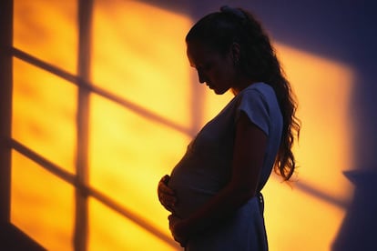Una adolescente embarazada, en penumbra. 