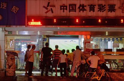 Un establecimiento en Shanghai ofrece el partido de octavos entre Rusia y Brasil en una pantalla que da a la calle, el 2 de julio de 2018.