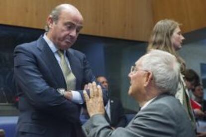 El ministro de Finanzas de Alemania, Wolfgang Schaeuble (d), habla con su homólogo español, Luis de Guindos (i), ayer antes del encuentro de los ministros de Finanzas del Eurogrupo en Luxemburgo.