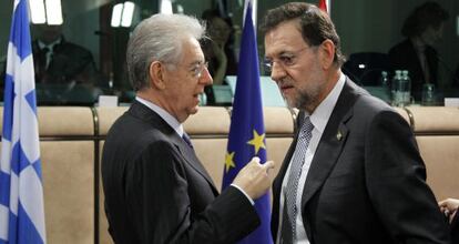 El primer ministro de Italia, Mario Monti, conversa con Mariano Rajoy durante la reunión del Eurogrupo de ayer.