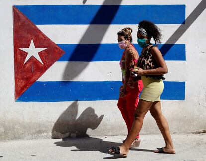 Dos mujeres caminan frente a un grafiti de la bandera cubana, este jueves en La Habana.