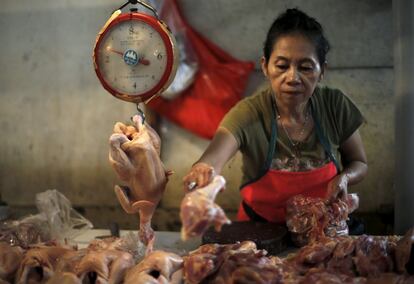 Una vendedora de pollos prepara para sus productos en su puesto del mercado Senén en Yakarta, Indonesia.