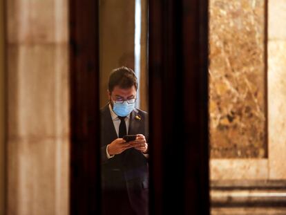 GRAFCAT7215. BARCELONA (ESPAÑA), 20/01/2021.- El vicepresidente del Govern con funciones de Presidente, Pere Aragonés, consulta su móvil en los pasillos del Parlament antes de que arranque la reunión de la diputación permanente con el debate sobre las solicitudes de comparecencia del conseller de Empresa y Conocimiento, Ramon Tremosa, y del conseller de Educación, Josep Bargalló. EFE/ Quique García