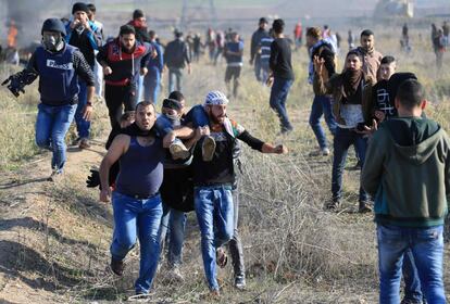 Un grupo de jóvenes palestinos llevan a un compañero herido durante los enfrentamientos con las fuerzas israelíes cerca de la cerca fronteriza con Israel, al este de la ciudad de Gaza.