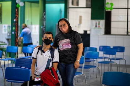 Douglas ao lado da secretária Luzia, que o ajudou a voltar para a escola.