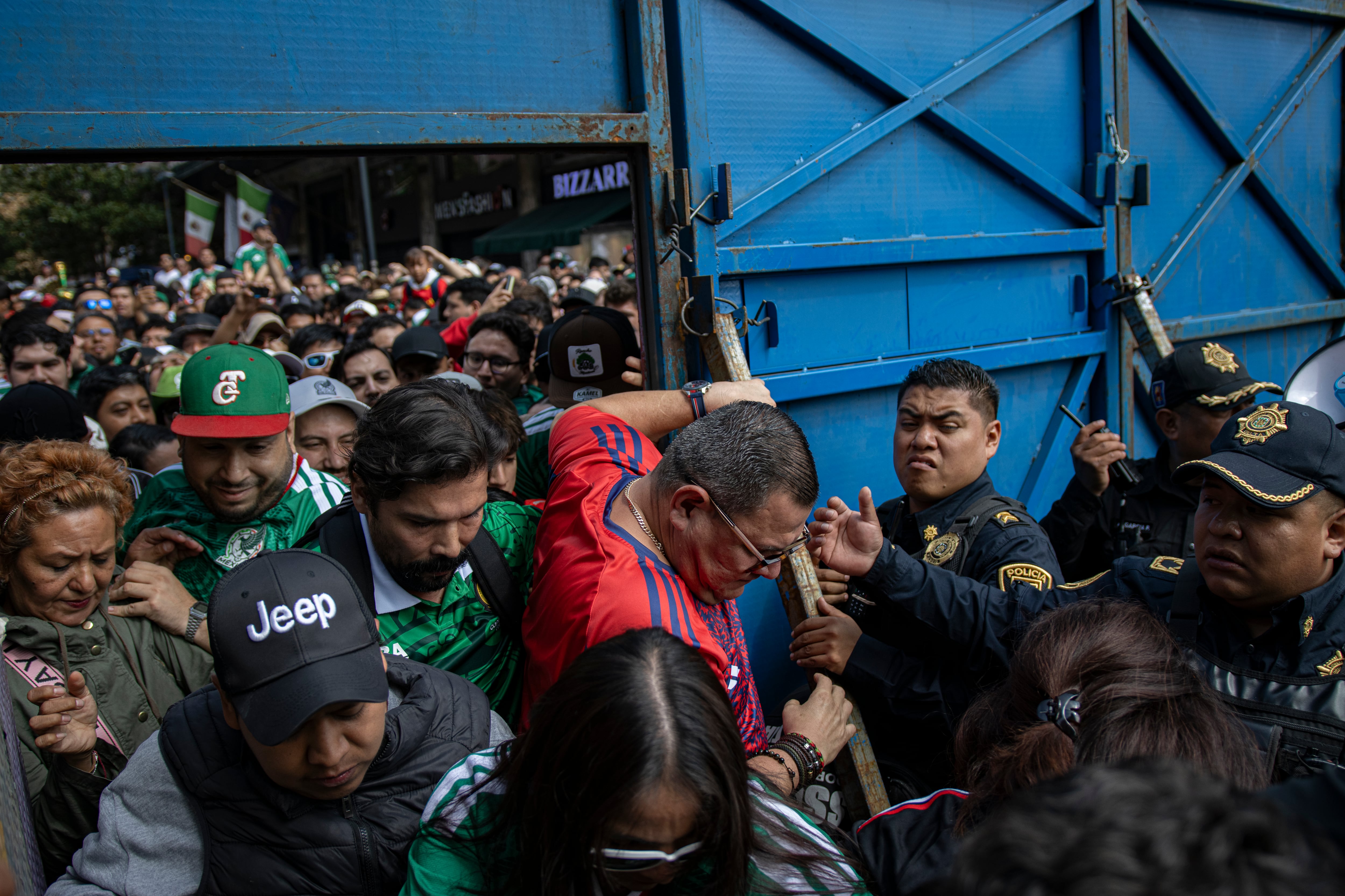 Personas ingresan al FIFA Fan Fest en el Zócalo capitalino, este jueves.