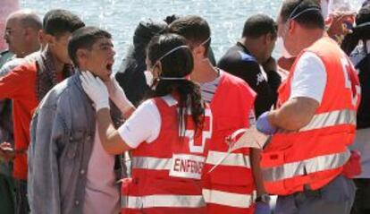 Miembros de la Cruz Roja atienden a inmigrantes en el Puerto de Málaga.