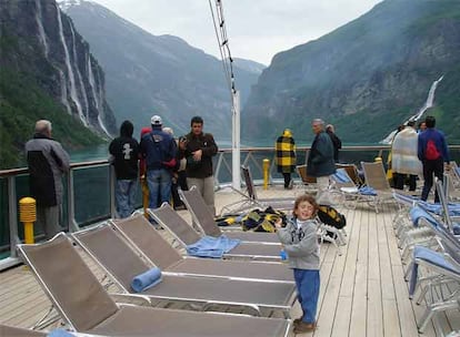 Kai Albillo, cámara de vídeo en mano, y su hijo David, a bordo del <i>Costa Atlántica</i> en junio de 2006, en un crucero por los fiordos noruegos. Al fondo, Geiranger.