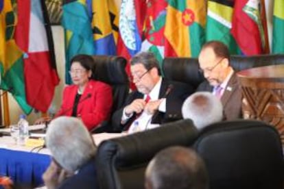 Fotografía cedida por el Caricom que muestra a (i-d) la primera ministra de Trinidad y Tobago, Kamla Persad Bissessar; el primer ministro de San Vicente y Granadinas y presidente de turno de Caricom, Ralph Gonsalves; el secretario general de la Comunidad del Caribe (Caricom), Irwin LaRocque, mientras, este lunes 10 de marzo de 2014, en la primera jornada de la cumbre semestral de la Comunidad del Caribe (Caricom).