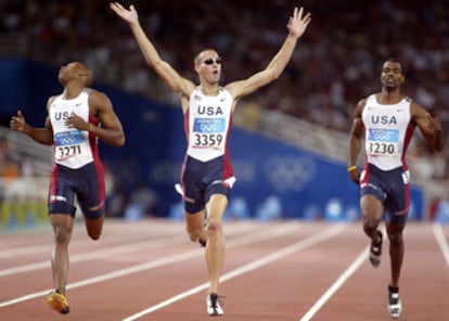 Jeremy Wariner levanta los brazos para celebrar su victoria, secundado por Otis Harris, a la izquierda, y Derrick Brew.