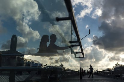 Una pareja toma fotos al atardecer en el paseo Tsim Sha Tsui en Hong Kong, China.