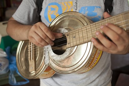 Un jóven de la orquesta de instrumentos reciclados de Cateura toca una guitarra hecha con latas de metal en la escuela de música del barrio en Asunción (Paraguay) el 29 de diciembre de 2013.

