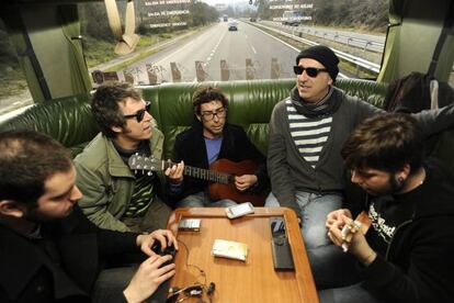 Amaro Ferreiro toca la guitarra, flanqueado por su hermano Iv&aacute;n (izquierda) y Nicol&aacute;s Pastoriza, ayer en el autob&uacute;s.