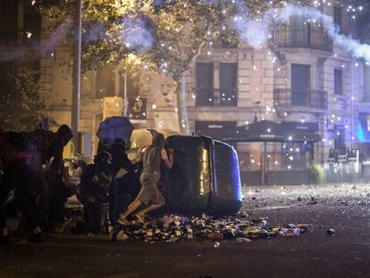 Manifestantes y Mossos d'Esquadra se enfrentan durante el lanzamiento de una bengala.