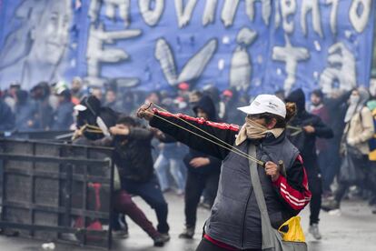 Manifestantes usan tirachinas para arrojar piedras contra la policía frente al Congreso.