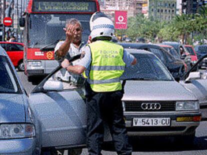 Un conductor dirigiéndose a un policía local en uno de los puentes cortados ayer al tráfico.