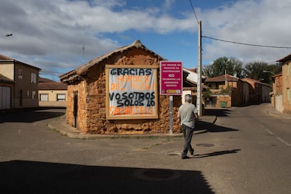 Un hombre pasea frente de un cartel hecho por los vecinos en agradecimiento al trabajo que hicieron los vecinos de Calzada de la Valdería al quedarse defendiendo la localidad en el incendio forestal del pasado mes de agosto.
