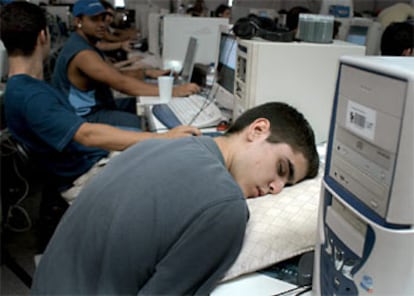 Un joven duerme junto a su ordenador durante el primer día de la séptima edición de la Campus Party.