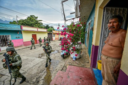 A man watches around 500 Army elements deploy in the municipality of Frontera Comalapa, on September 27.