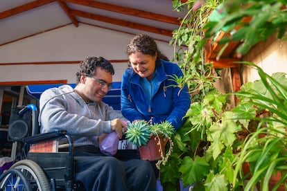 Una mujer ayuda a un joven con parálisis cerebral.