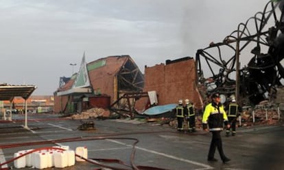 Dos bomberos, ante los restos del edificio de Leroy Merlin que se derrrumbó esta madrugada a causa de un incendio, sin que se produjeran víctimas, en el polígono El Carralero, en Majadahonda