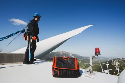 Un profesional trabaja en lo alto de un aerogenerador.