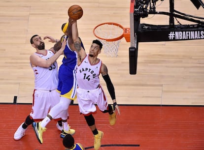 Danny Green, de los Toronto Raptors, entra a canasta mientras DeMarcus Cousins de Golden State Warriors le defiende, en el quinto partido de las finales de la NBA.