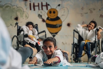 En el pueblo sirio de Aljiina, cerca de la ciudad de Alepo, Wasim Satot ha abierto una escuela de kárate para niños. Lo que lo hace especial es que a las niñas y niños con y sin discapacidad se les enseña juntos. Tienen entre seis y 15 años. Con su escuela, Satot quiere crear un sentido de comunidad y superar cualquier experiencia de guerra de las mentes de los niños. El fotógrafo sirio Anas Alkharboutli ha documentado cómo el kárate ha conseguido hacer que los niños sean felices, fuertes y seguros de sí mismos; promover su resistencia y permitirles llevar una vida sin preocupaciones, aunque solo sea por unos pocas horas.