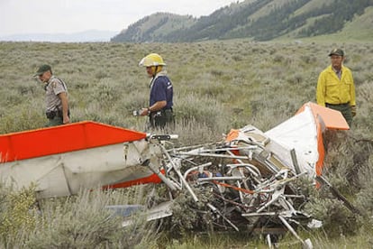 Los investigadores revisan los restos de la avioneta en la que viajaba John Walton.