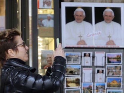 Una mujer fotografía una imagen de Benedicto XVI