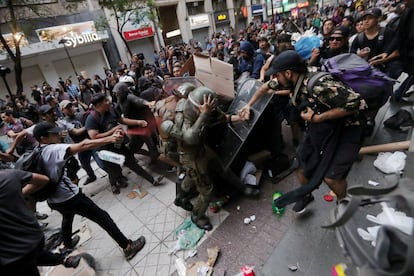 Activistas indígenas mapuches se enfrentan a policías antidisturbios durante una protesta en Santiago de Chile (Chile), el 27 de diciembre de 2018. La manifestación exigía justicia para Camilo Catrillanca, un hombre mapuche indígena que recibió un disparo en la cabeza durante una operación policial. Los activistas también demandaban el respeto de sus derechos indígenas y las tierras para sus comunidades.