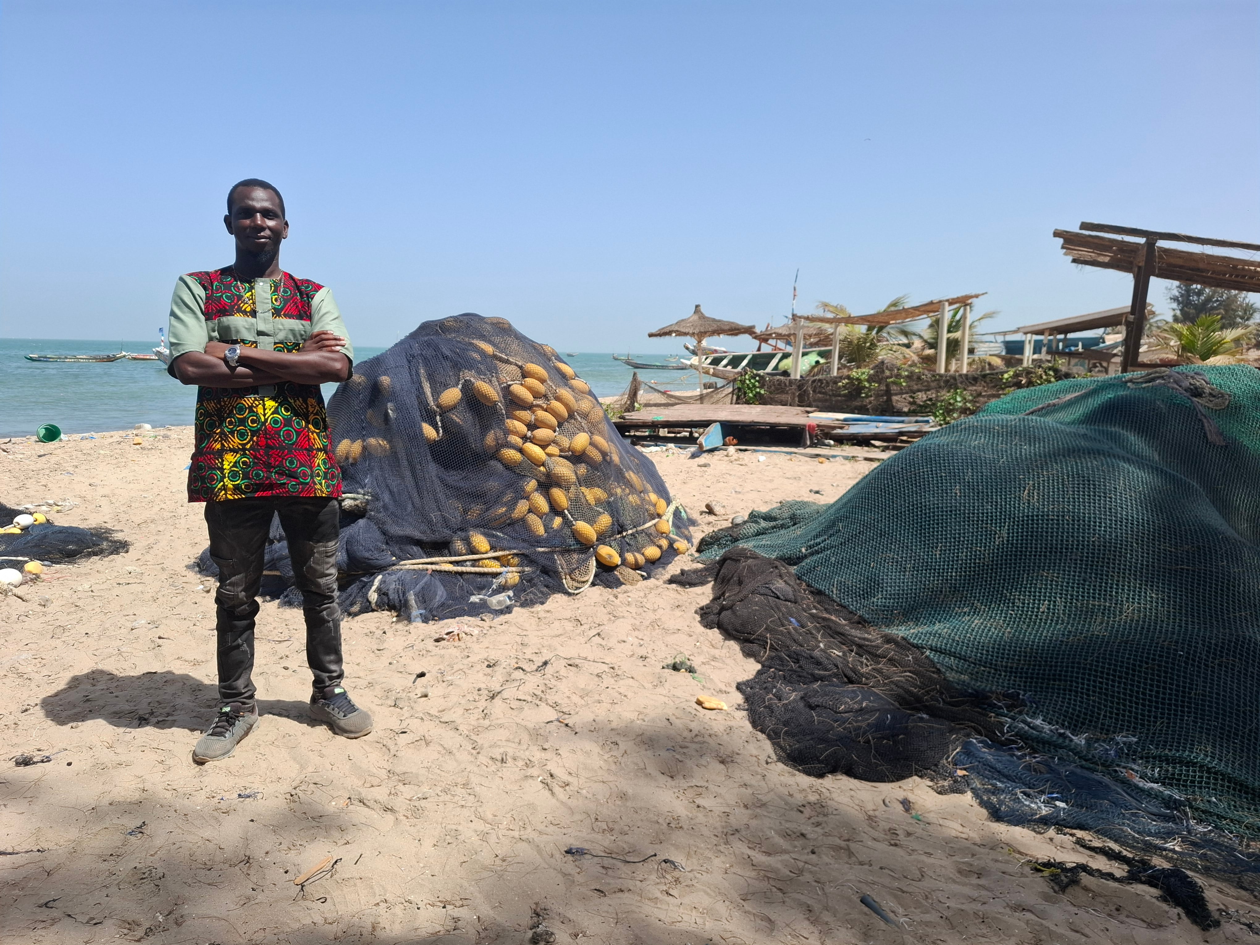 Ebrimah Dramé, activista gambiano que facilita información sobre las personas en ruta hacia Canarias, en la playa de Tanji (Gambia).